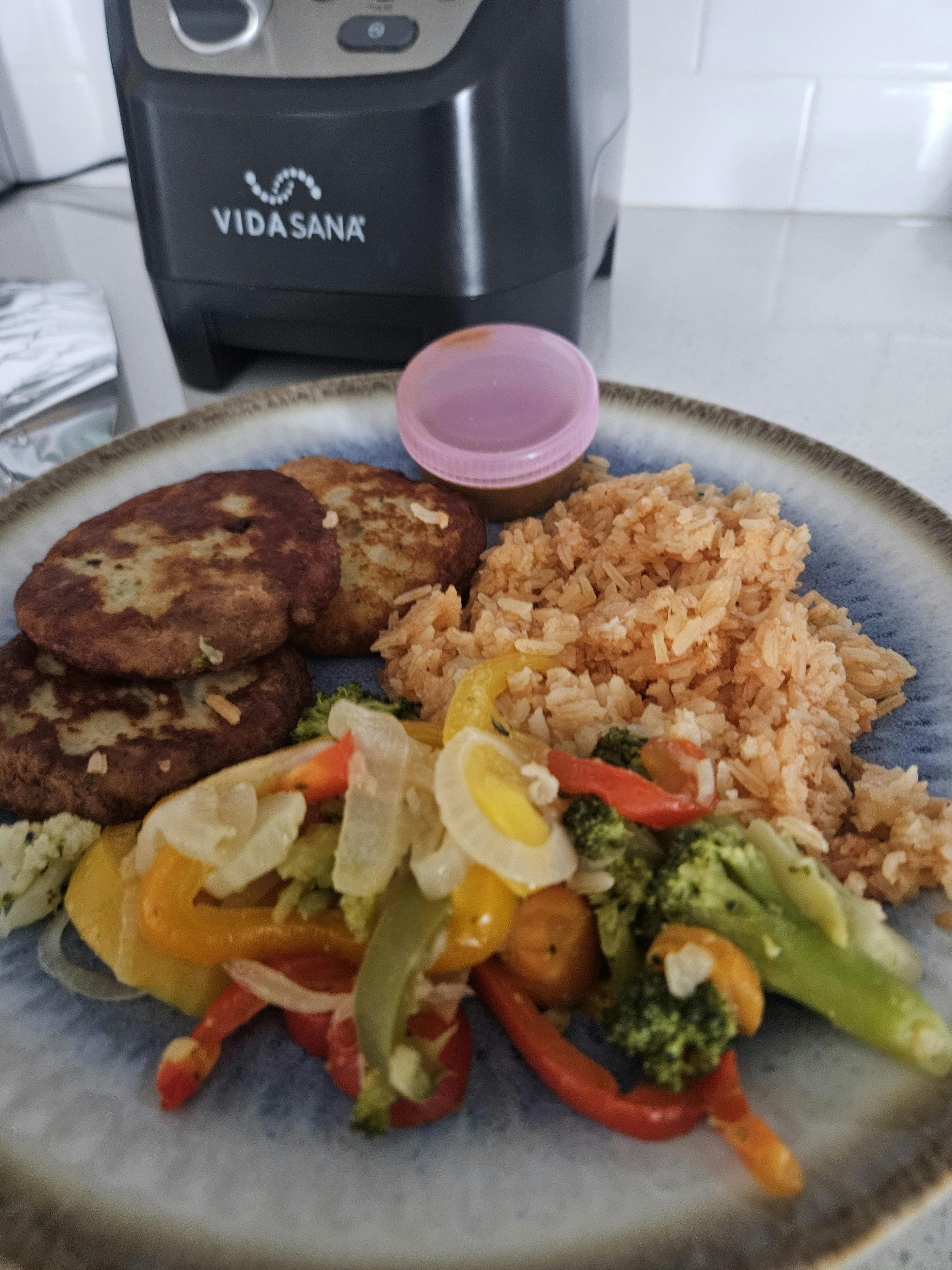 A meal with rice, vegetables, and three patties on a blue plate