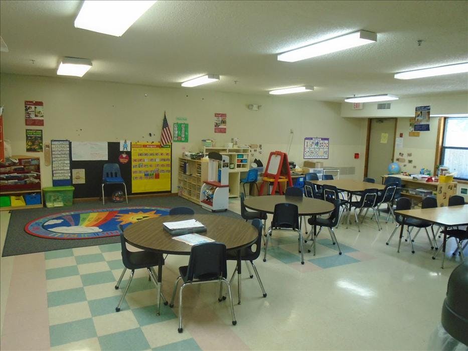 Classroom with multiple round and rectangular tables and chairs