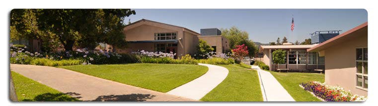 Building exterior with green lawn and winding pathways