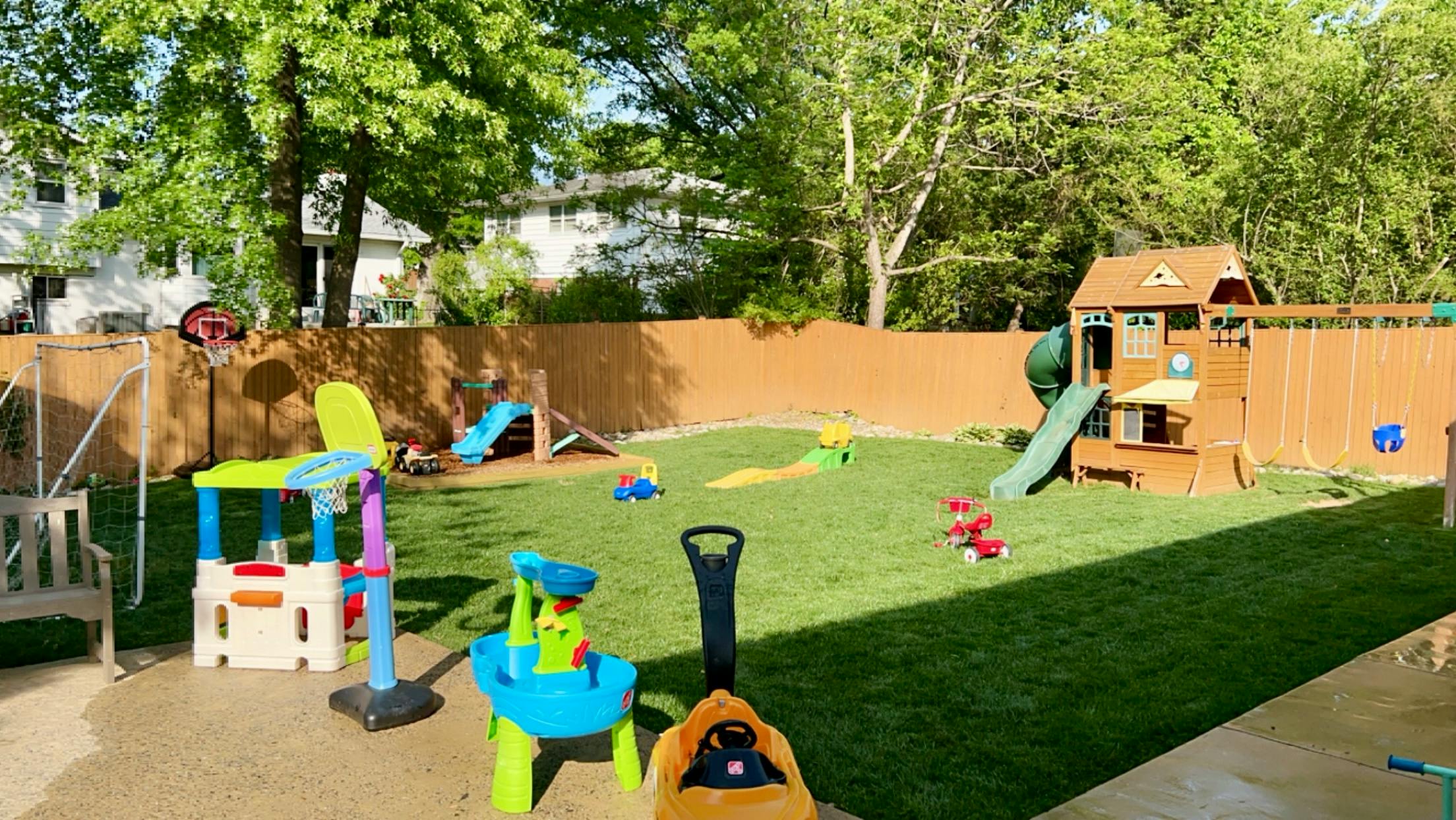 Outdoor play area with various toys and a playset with a slide