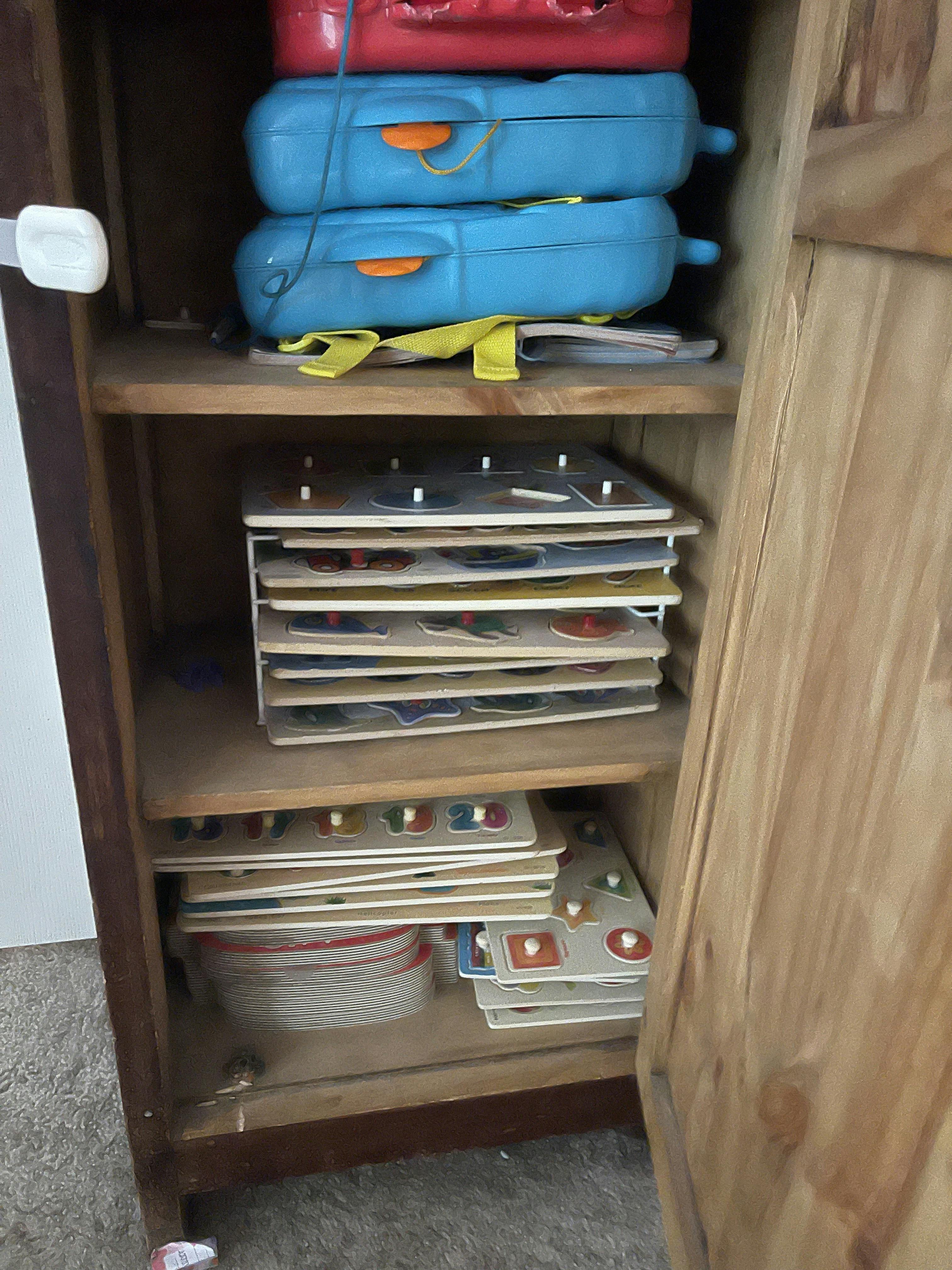Wooden cabinet with puzzles and suitcases