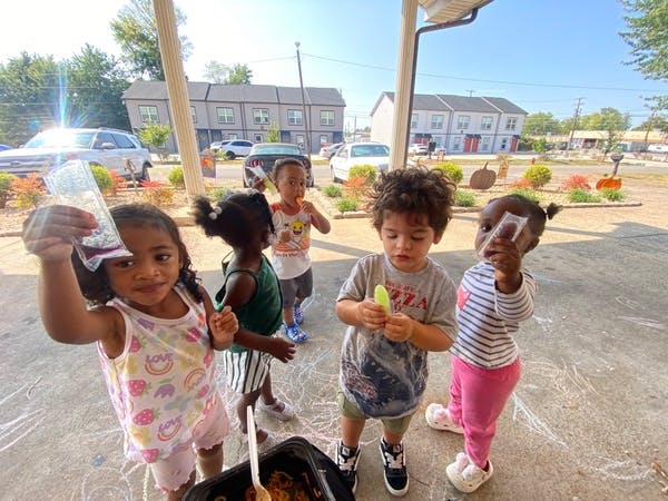 Four children holding frozen treats outside
