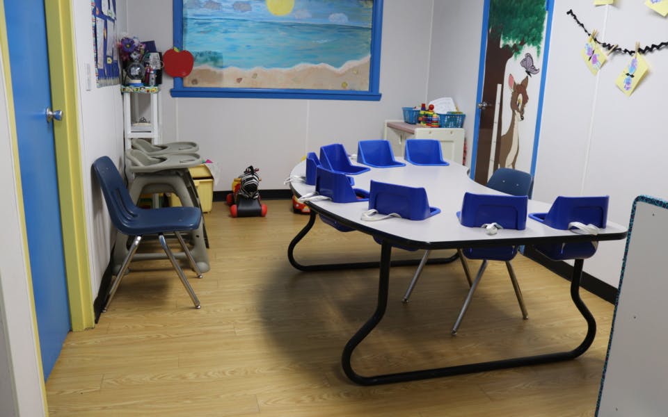 Classroom with a large table and blue chairs