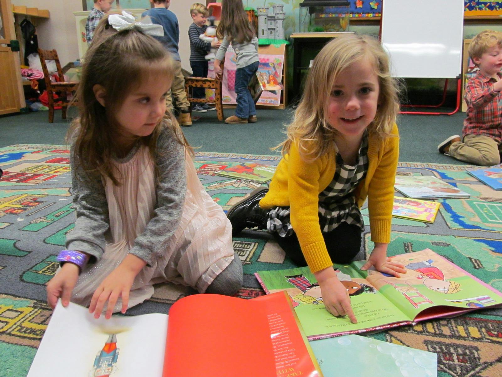 Two children on a rug looking at books