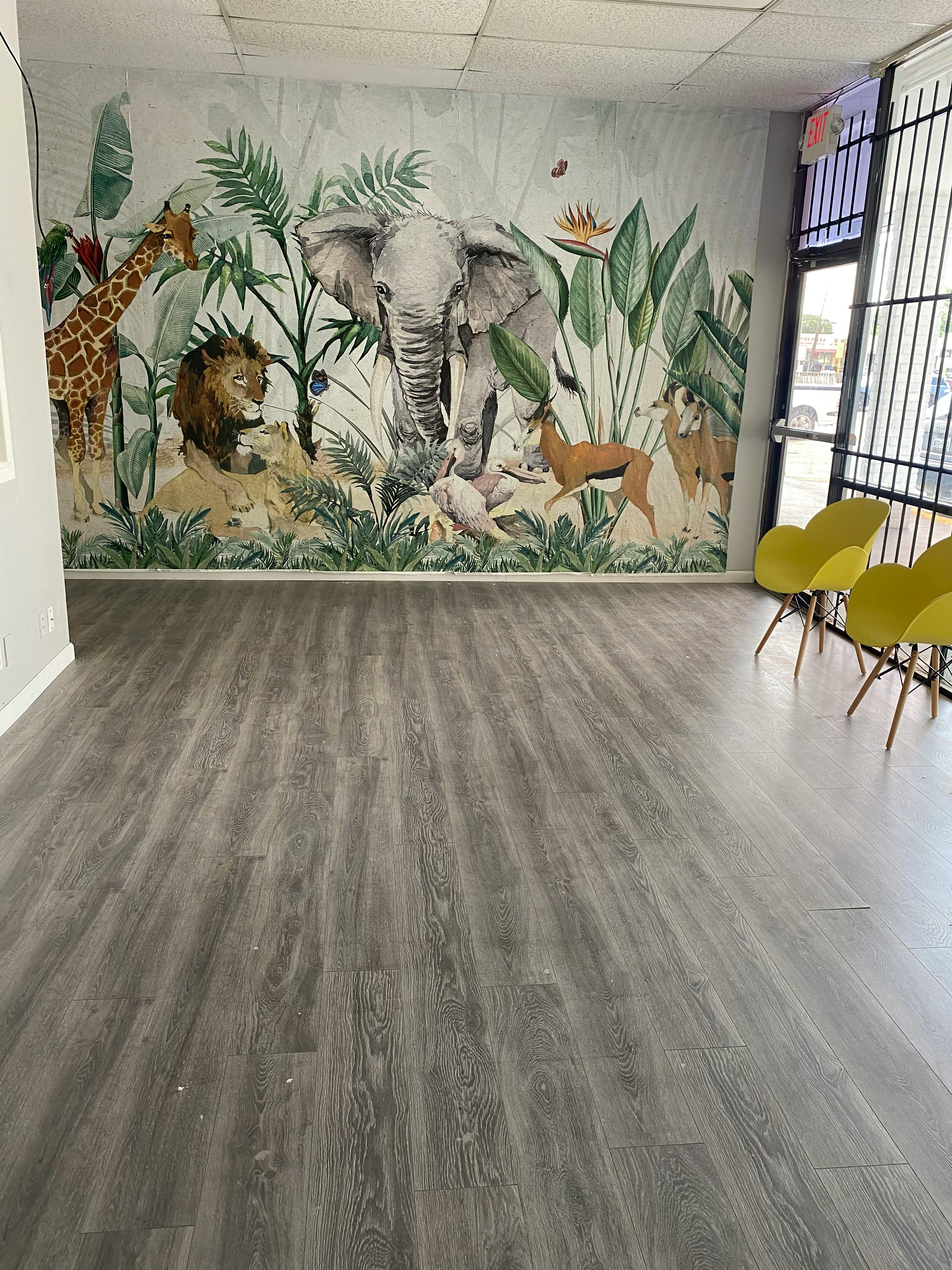 Wall mural of jungle animals including an elephant, giraffe, and lion