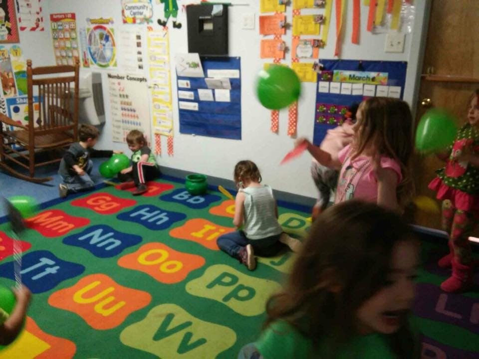 Children playing with balloons in a classroom