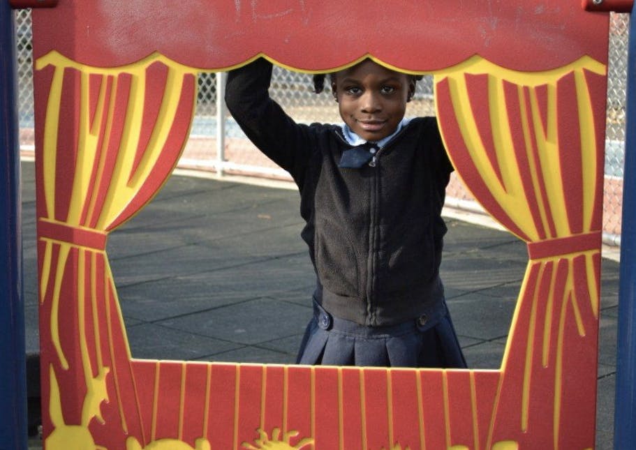 Child looking through a red and yellow play structure