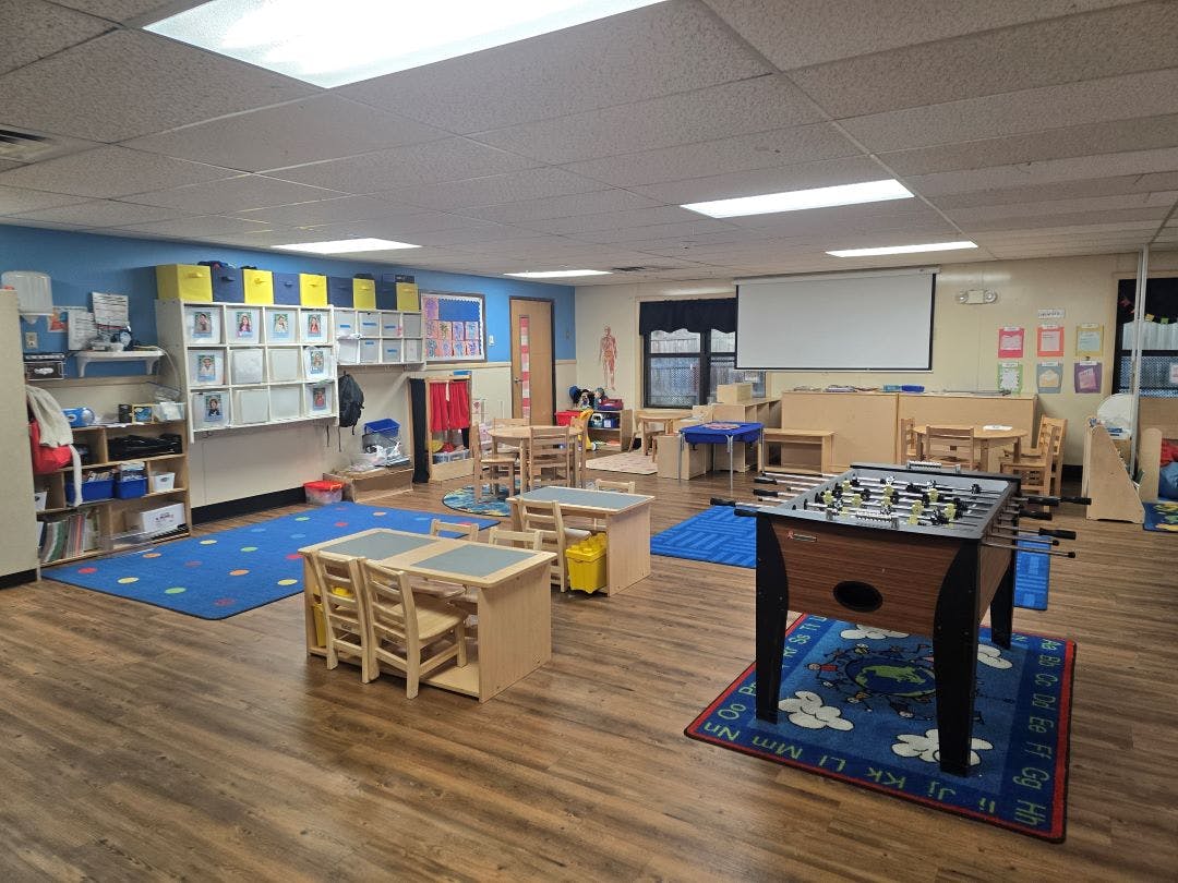 Classroom with small tables, chairs, and a foosball table