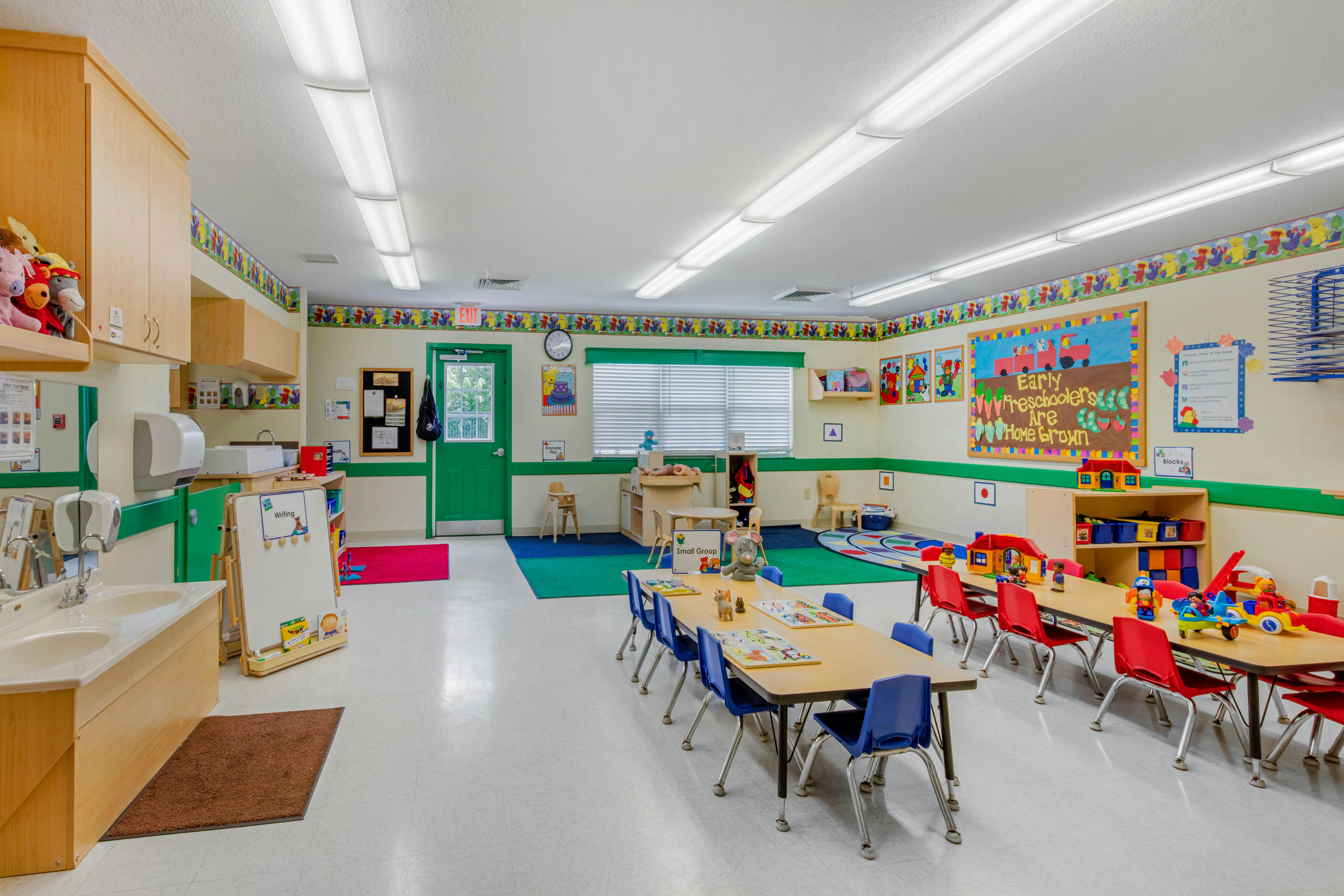 Preschool classroom with tables, chairs, toys, and sinks
