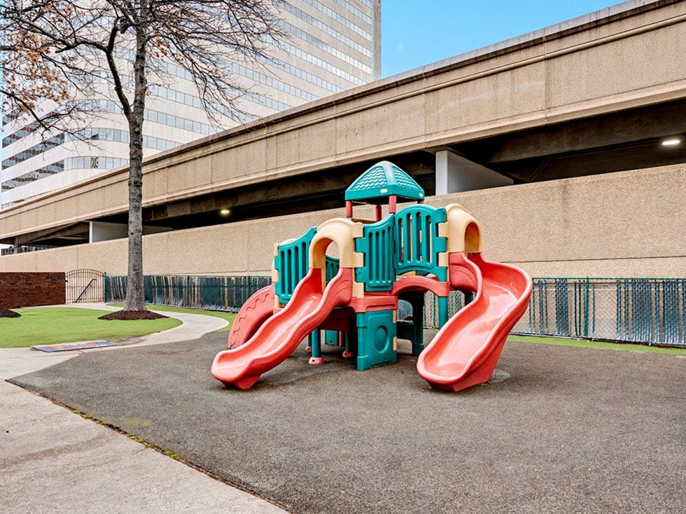 A colorful plastic playground structure with slides on soft ground