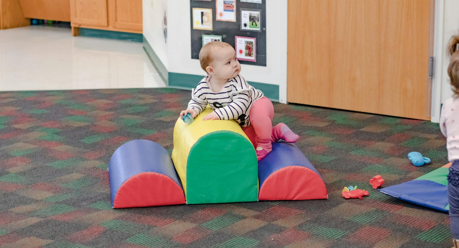 Child sitting on colorful soft play equipment