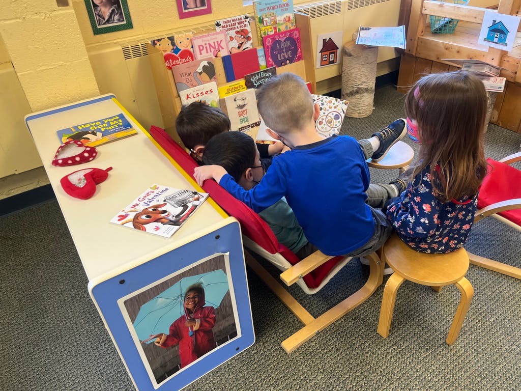 Children sitting and looking at books in a classroom