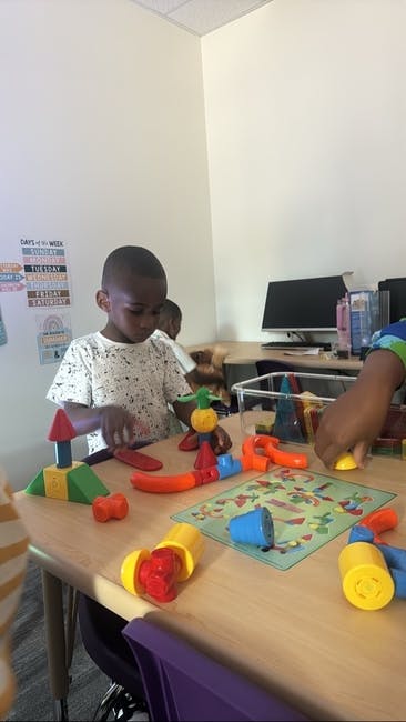 Child playing with colorful building blocks at a table