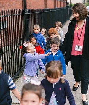 Adult and children walking on a sidewalk