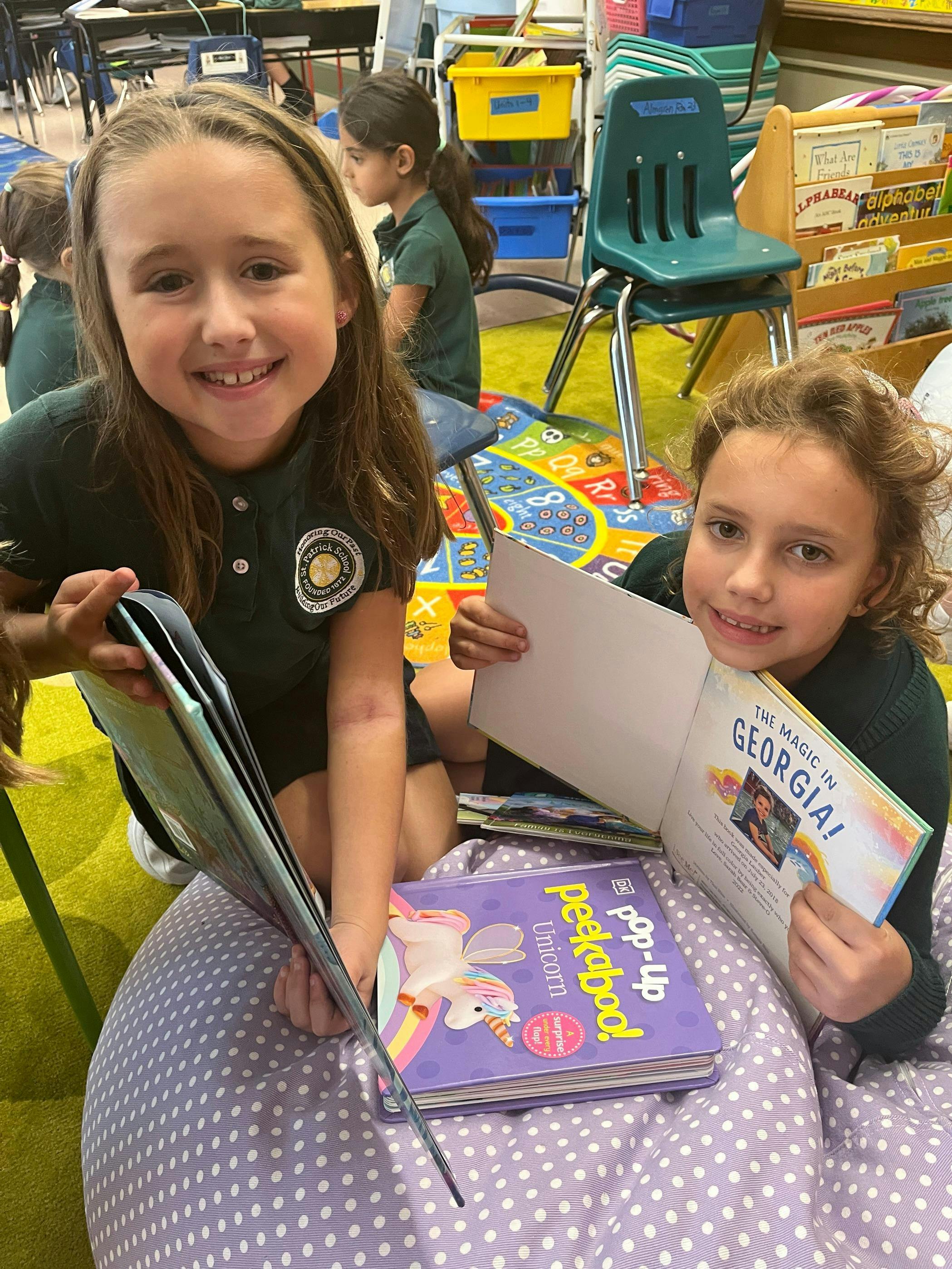 Two children reading books in a classroom