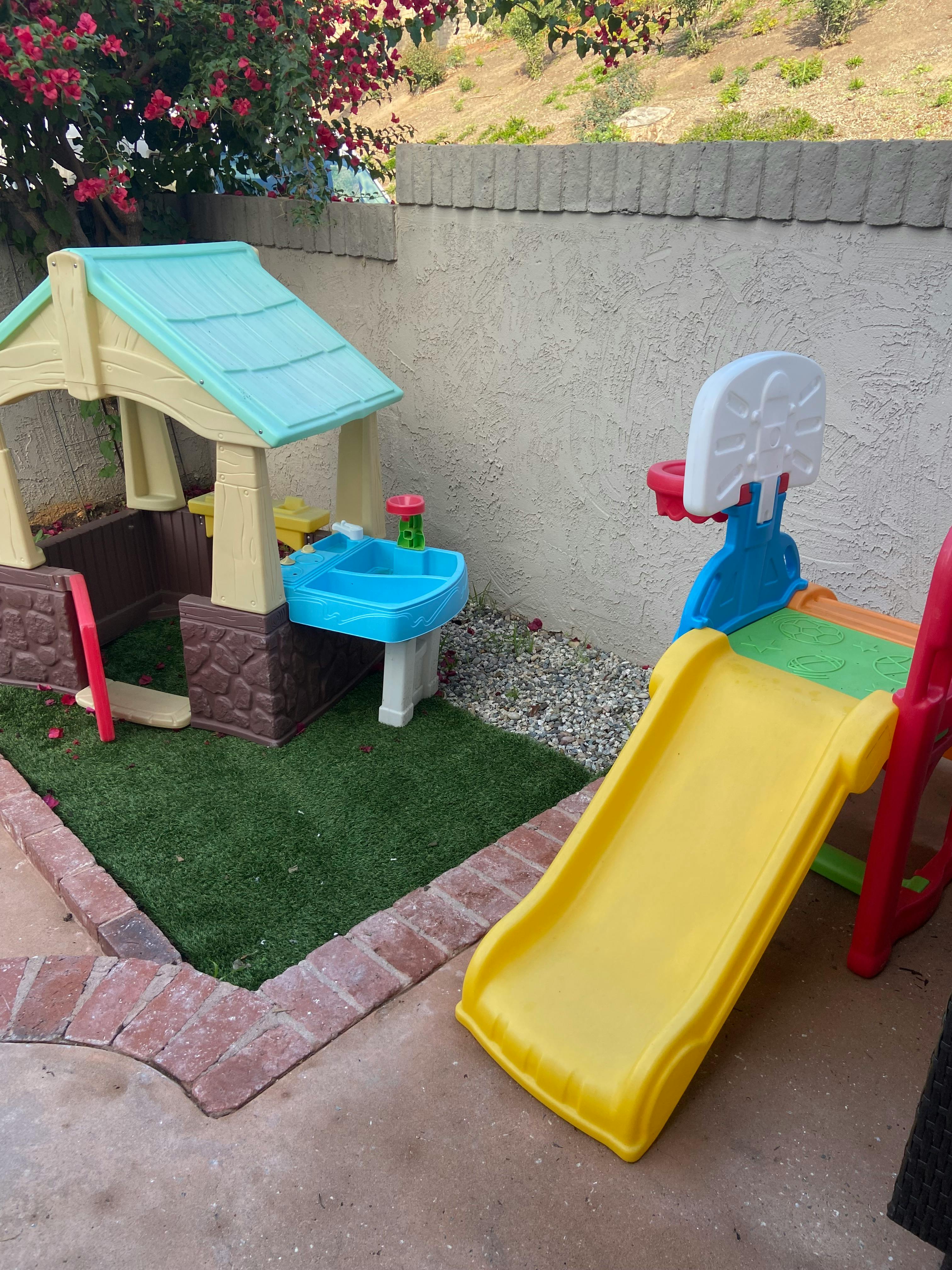 Colorful plastic children's playset with a yellow slide and basketball hoop