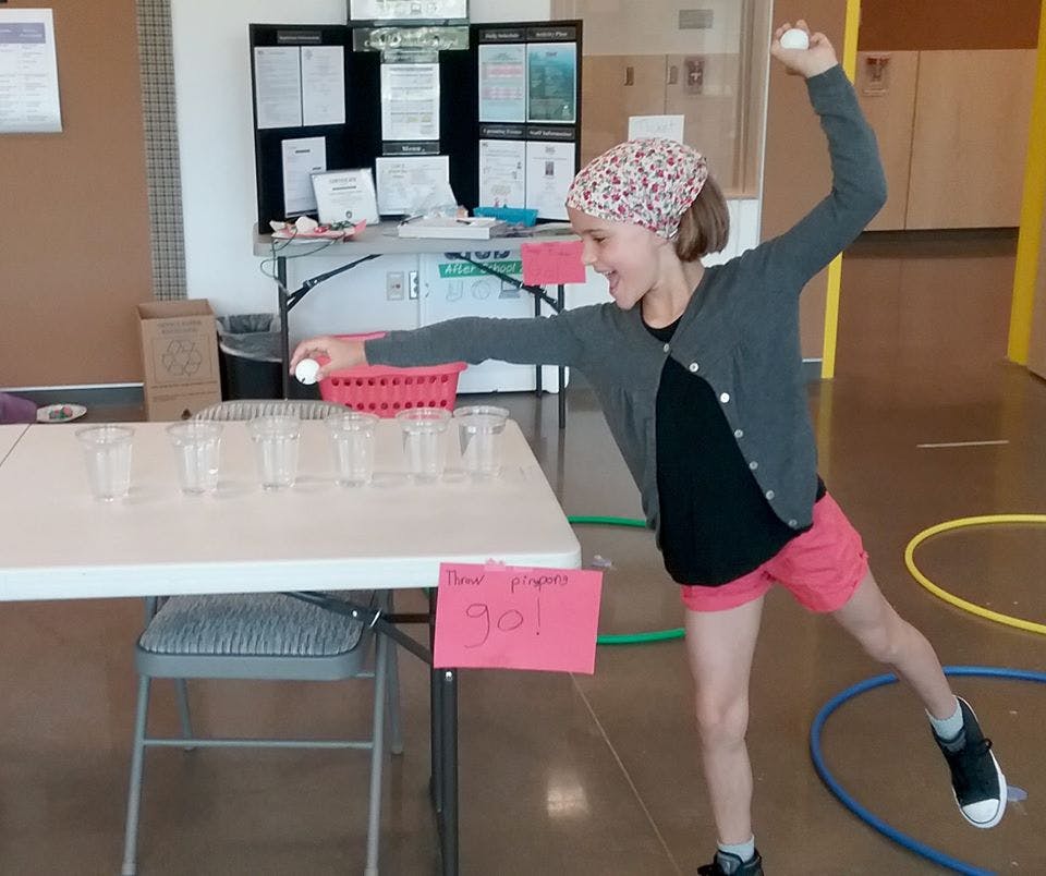 Child playing a game with cups and balls