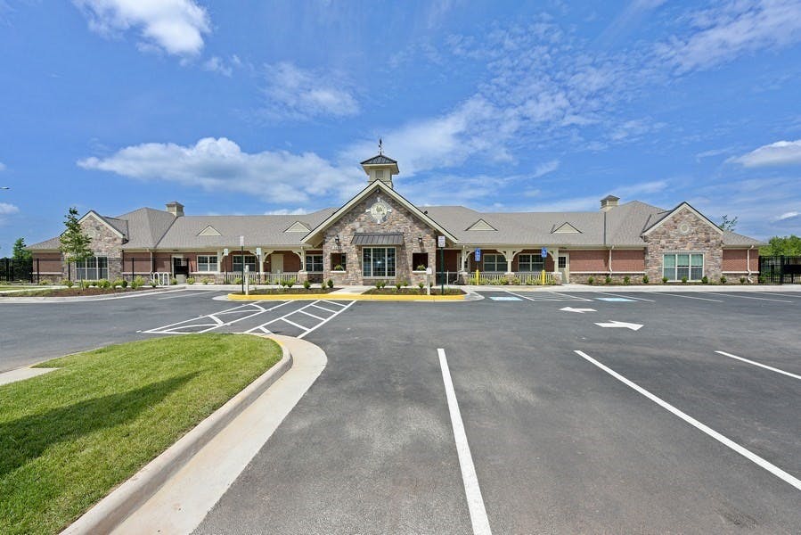 Large stone building with a cupola and a parking lot in front