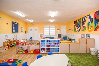 Empty classroom with toys, shelves, and a table