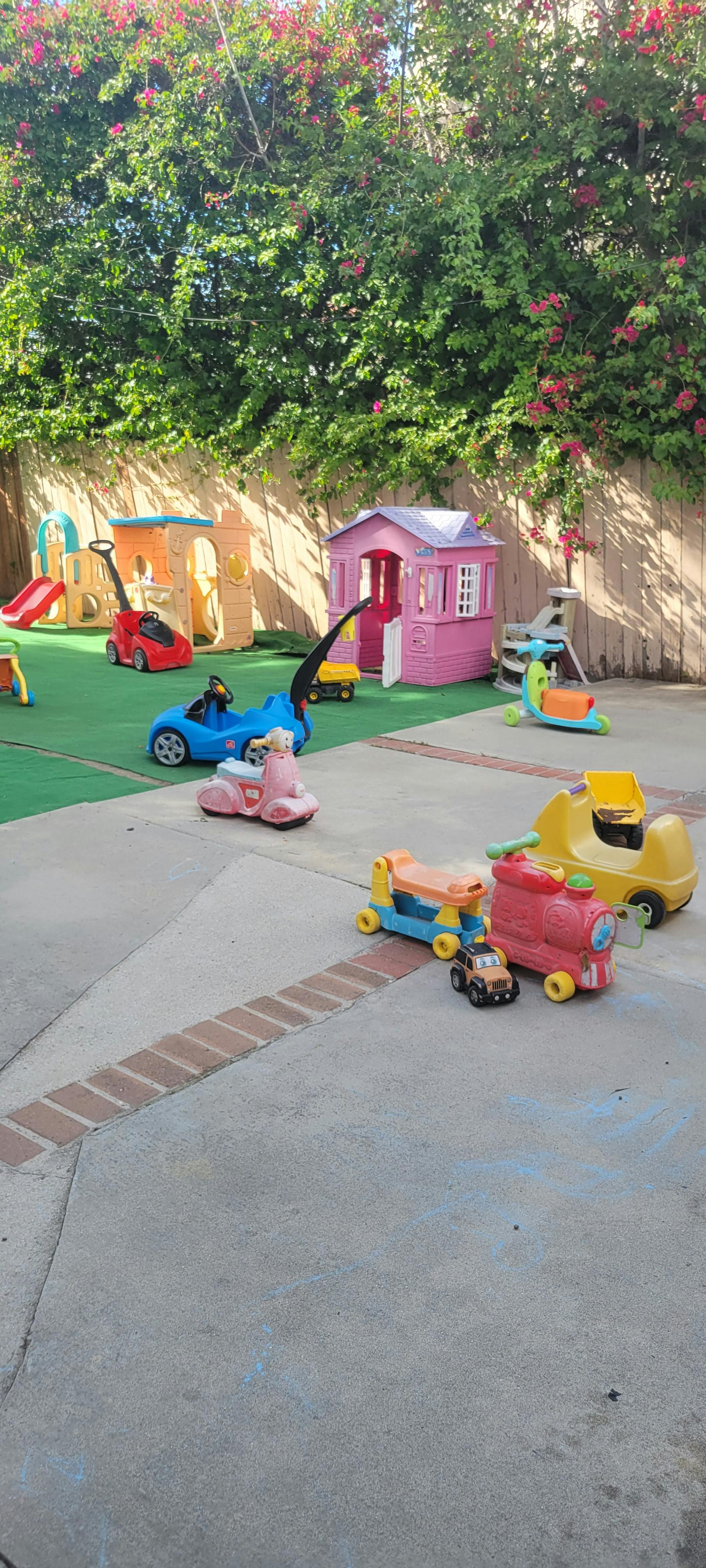 Playground area with plastic playhouses and ride-on toys