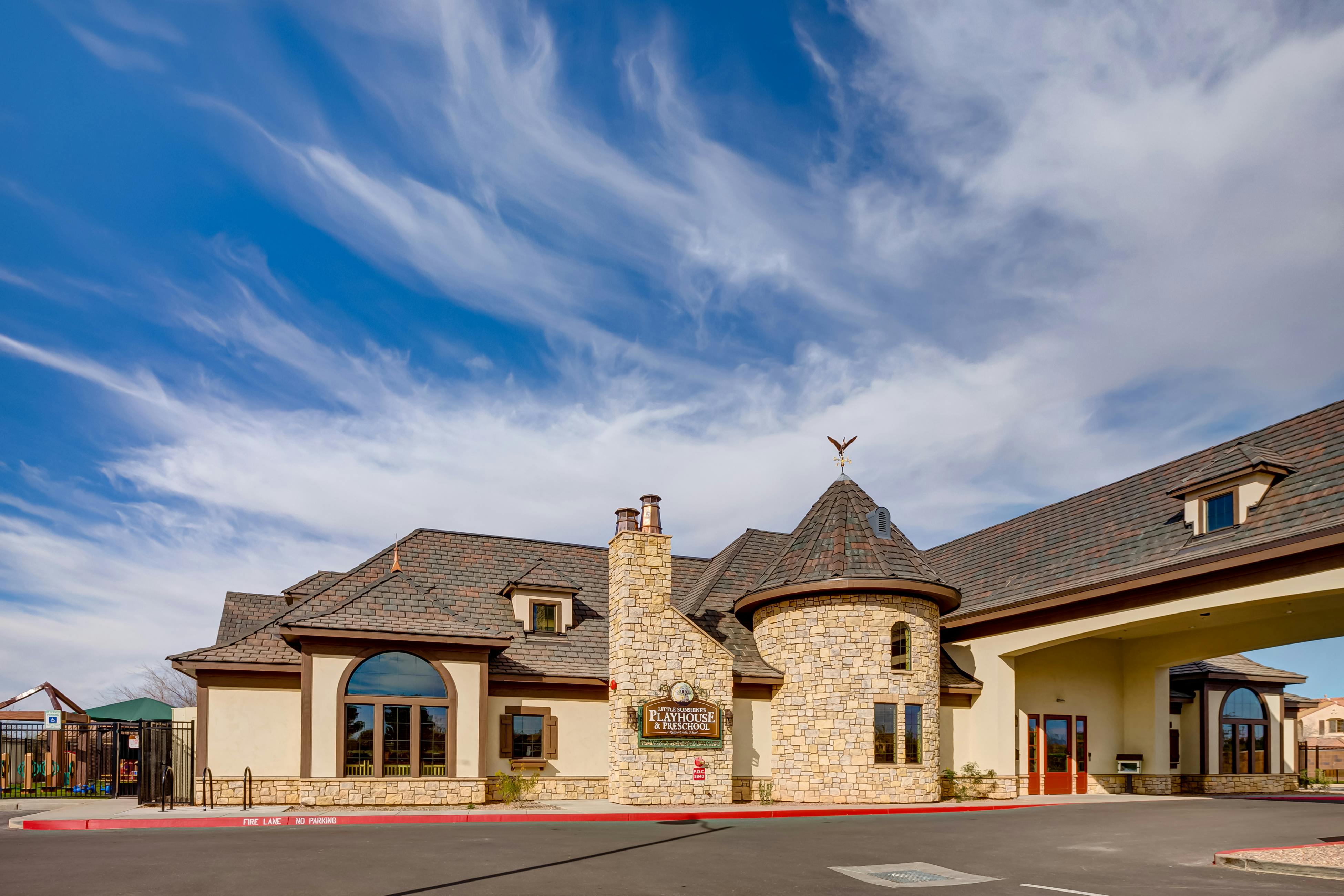 Building with stone facade, turret, and covered entrance
