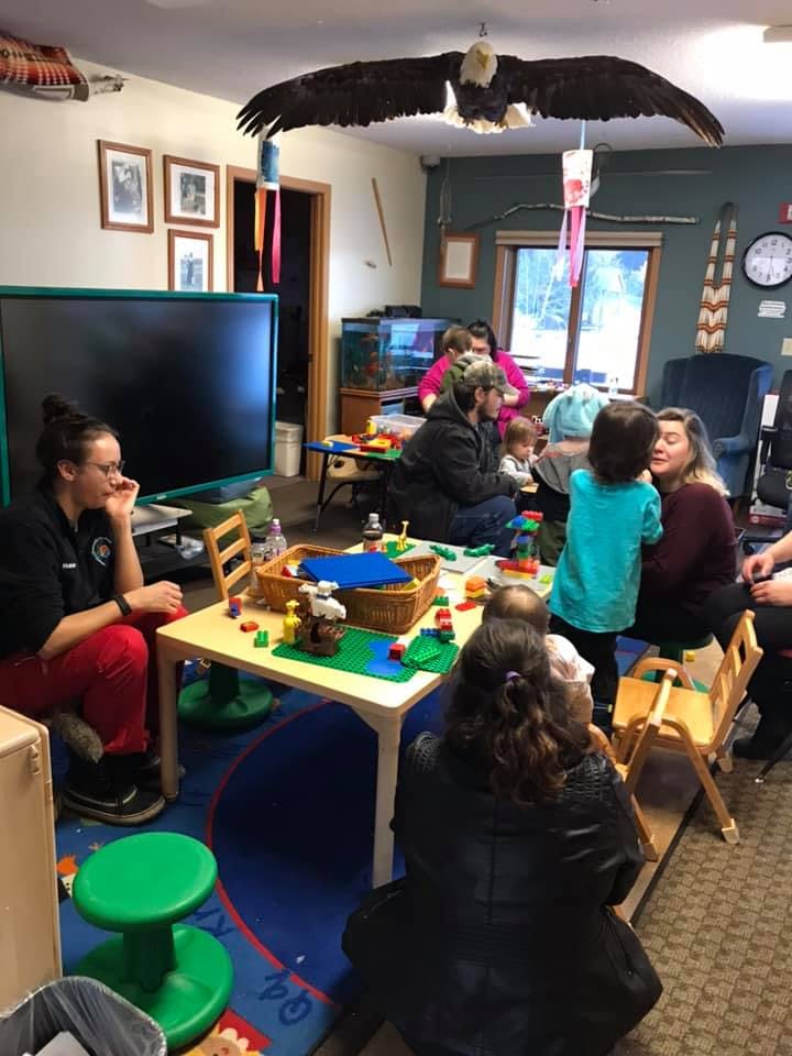 People and children gathered around tables in a room