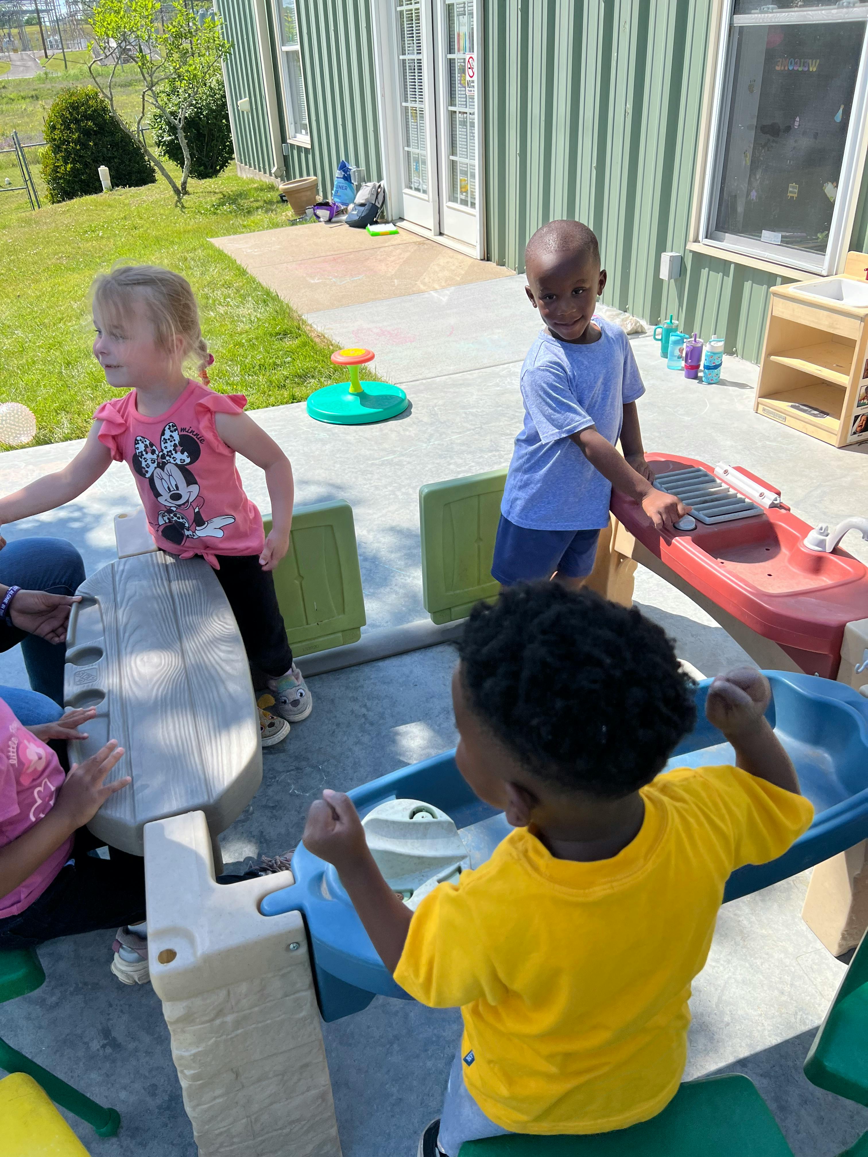 Three children playing with outdoor toy structures