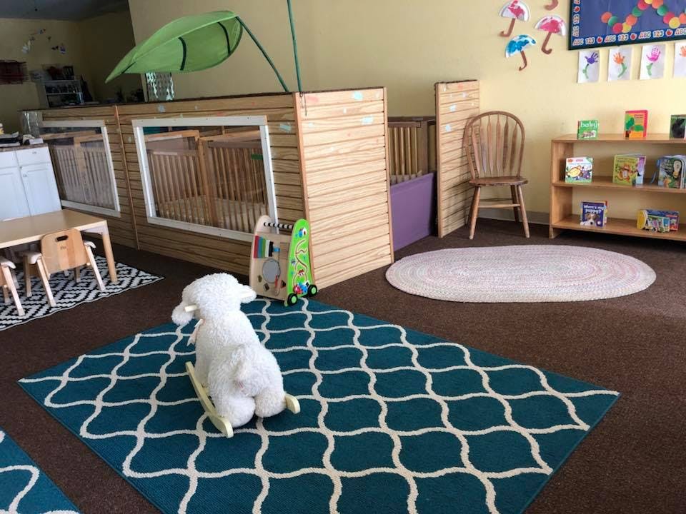 Playroom with cribs, small table and chairs, and a rocking horse
