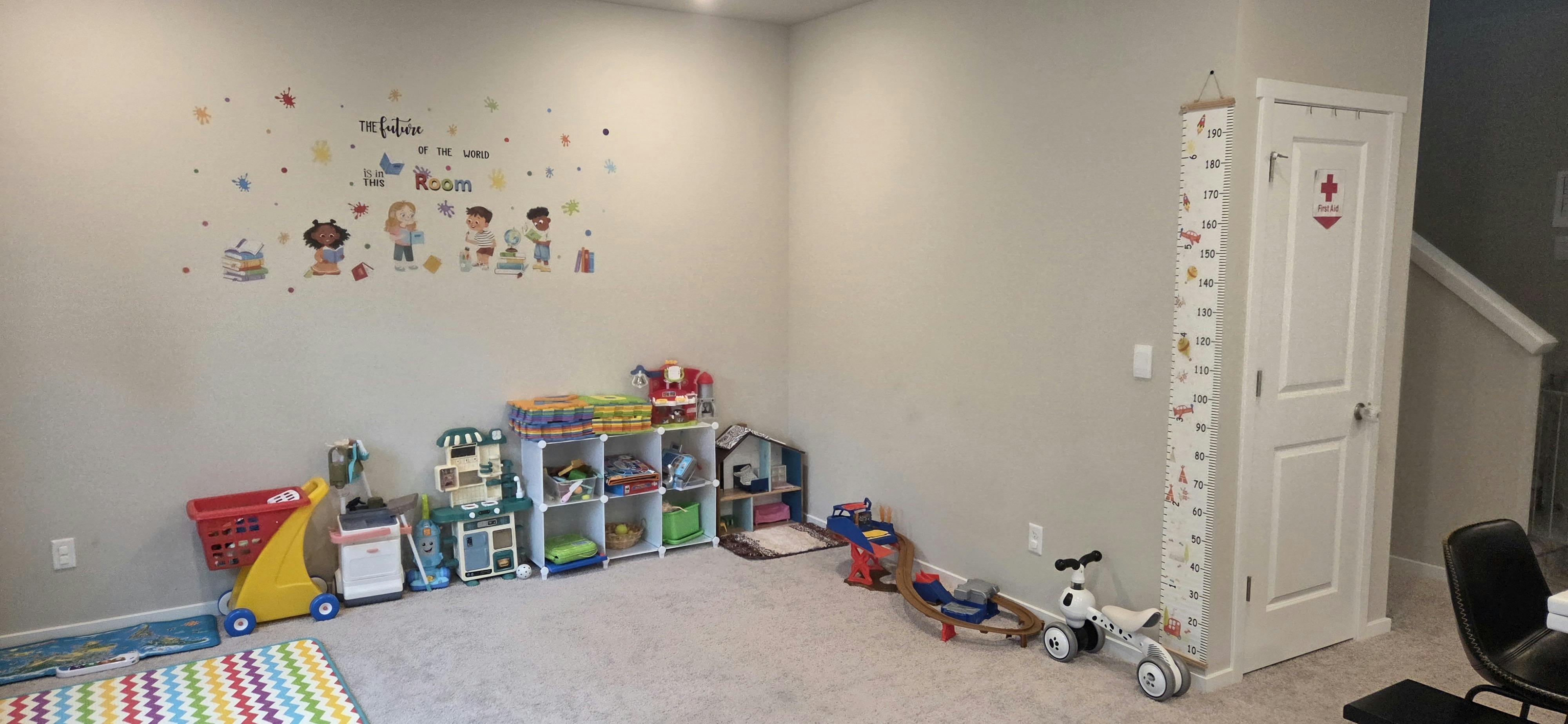 Playroom with toys, storage shelves, and wall decals