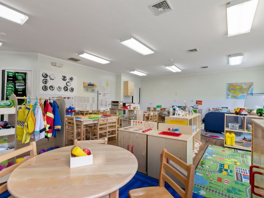 Classroom with small tables, chairs, and play areas