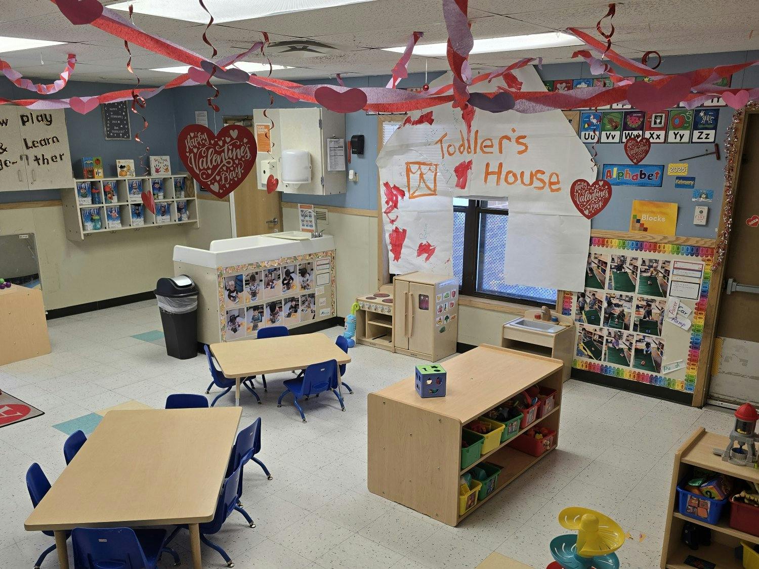 A classroom decorated for Valentine's Day with small tables and chairs