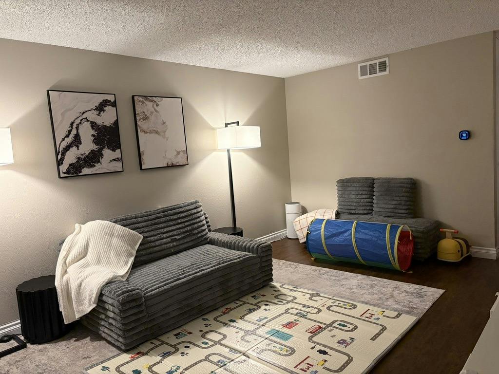 Playroom with floor mat, small couch, and toy tunnel