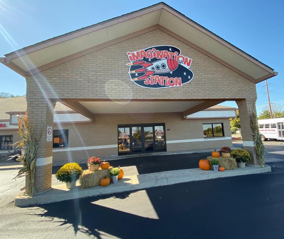 Building entrance with "Imagination Station" sign and fall decorations