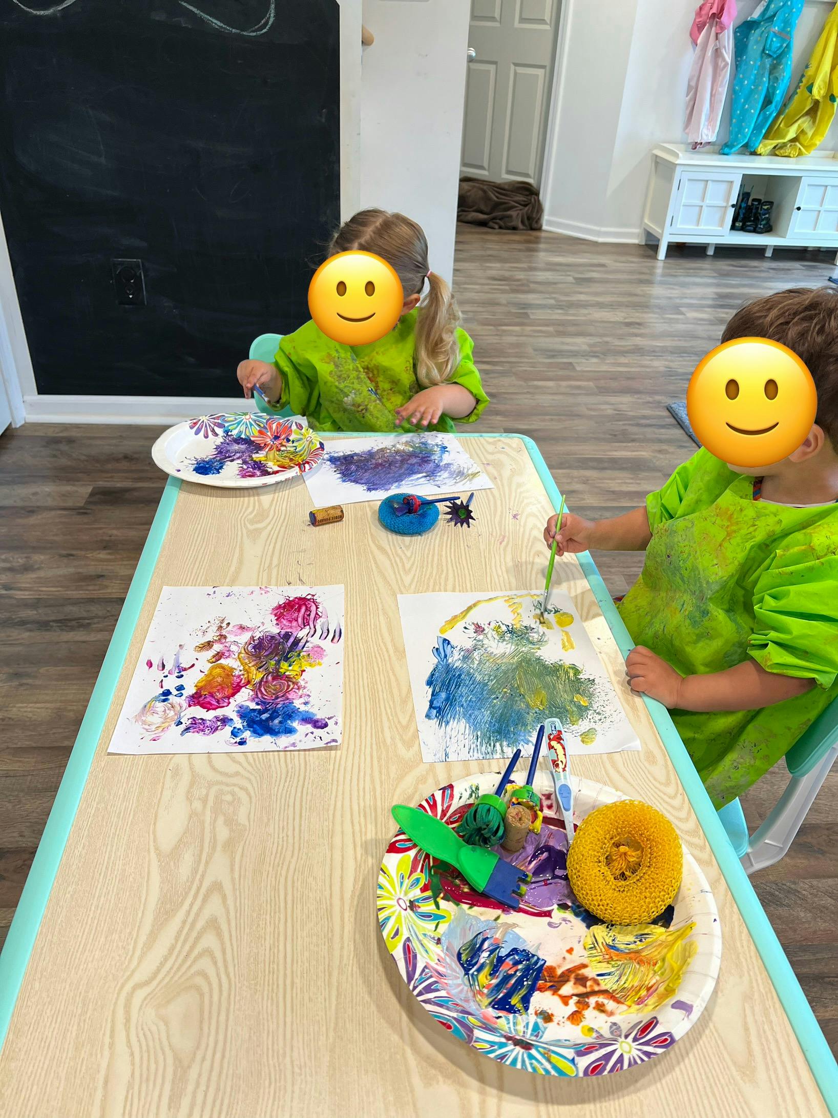 Two children painting at a table