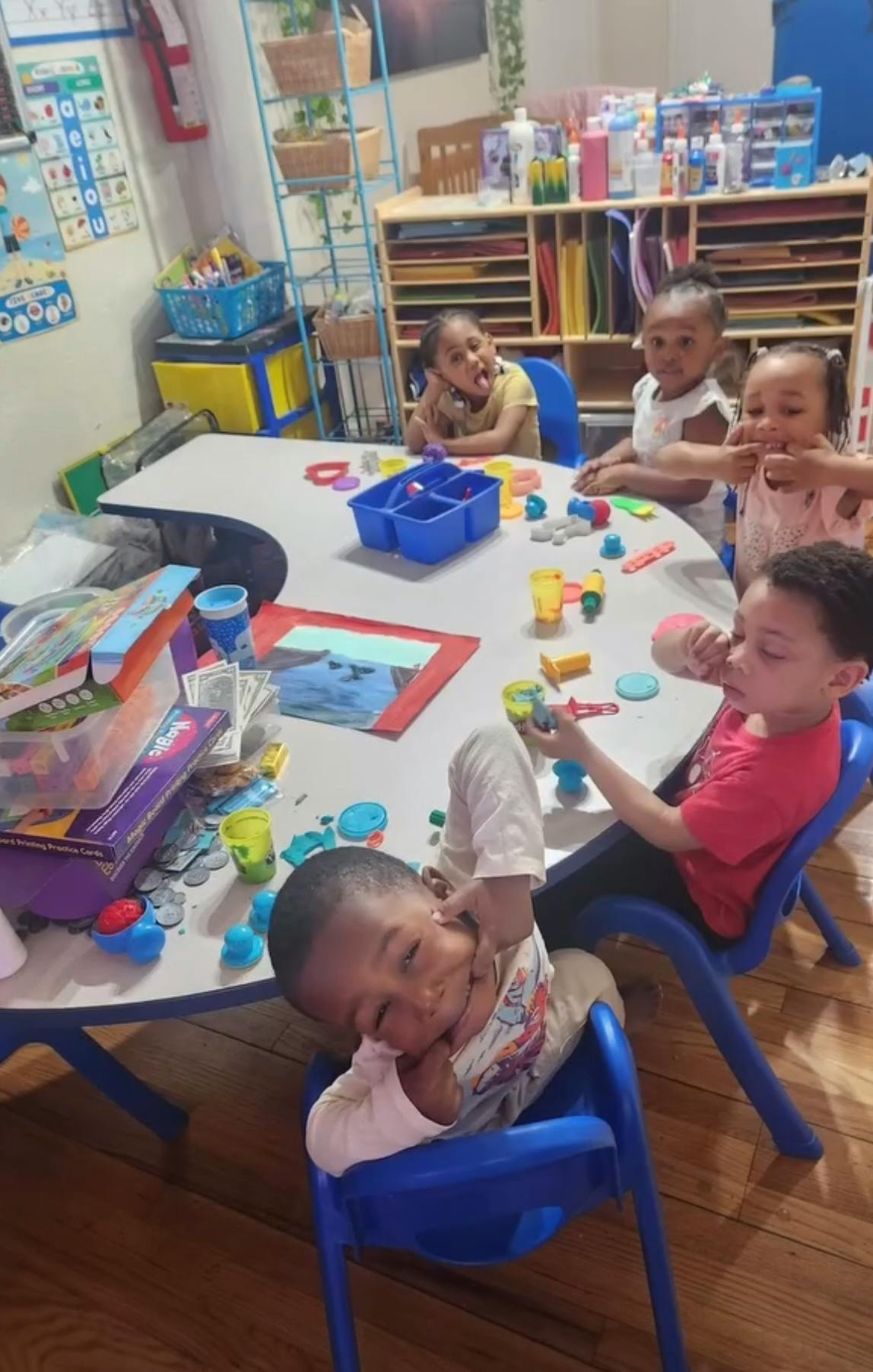 Multiple children sitting around a table with toys