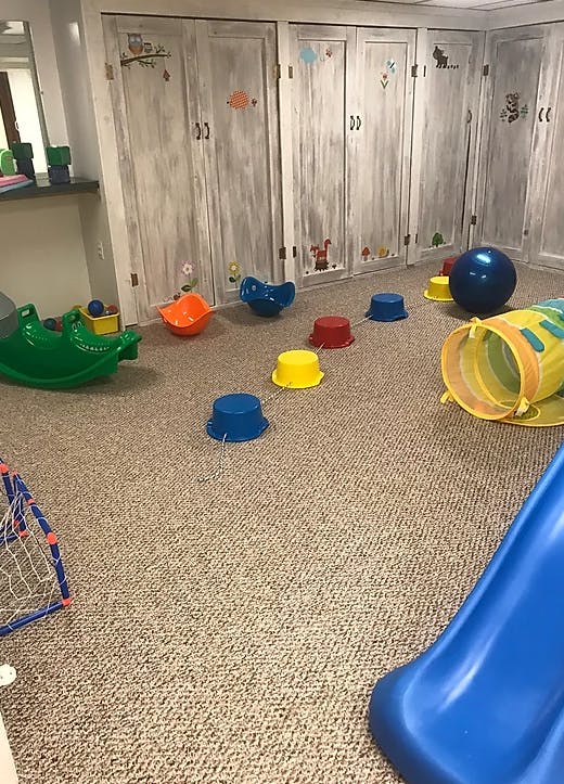 Playroom with various colorful toys on a carpeted floor