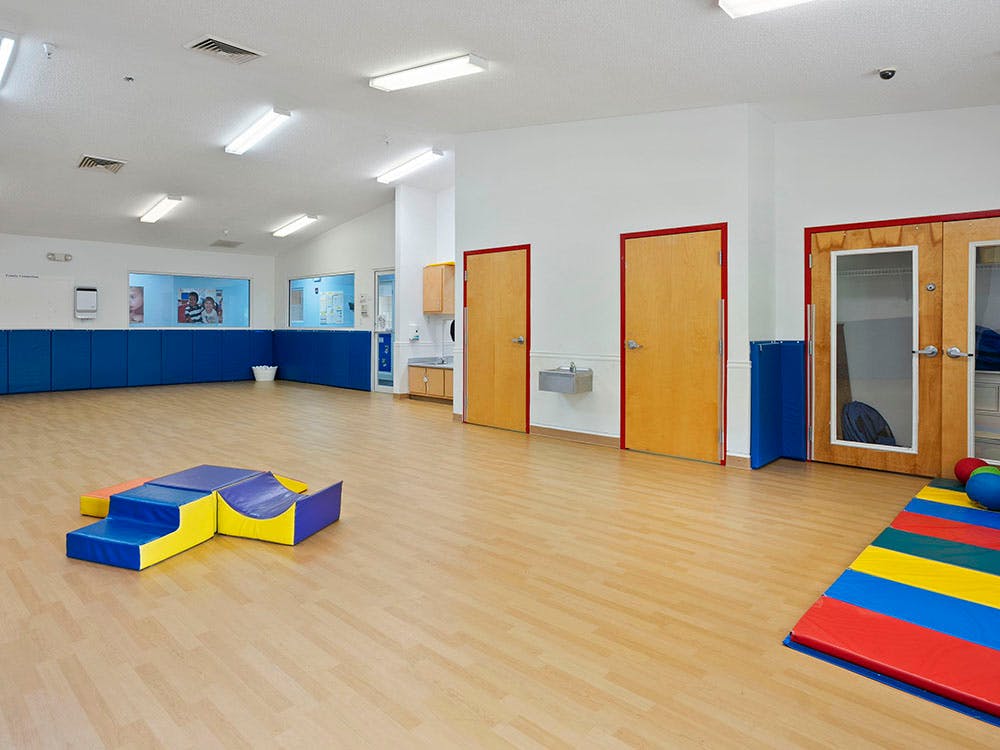 Empty classroom with colorful play equipment on light-colored flooring