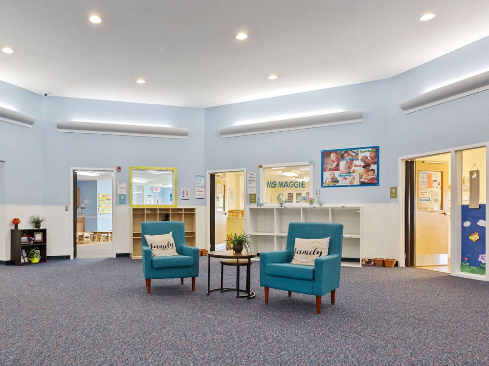 Lobby of a daycare or preschool with two blue chairs and open doorways
