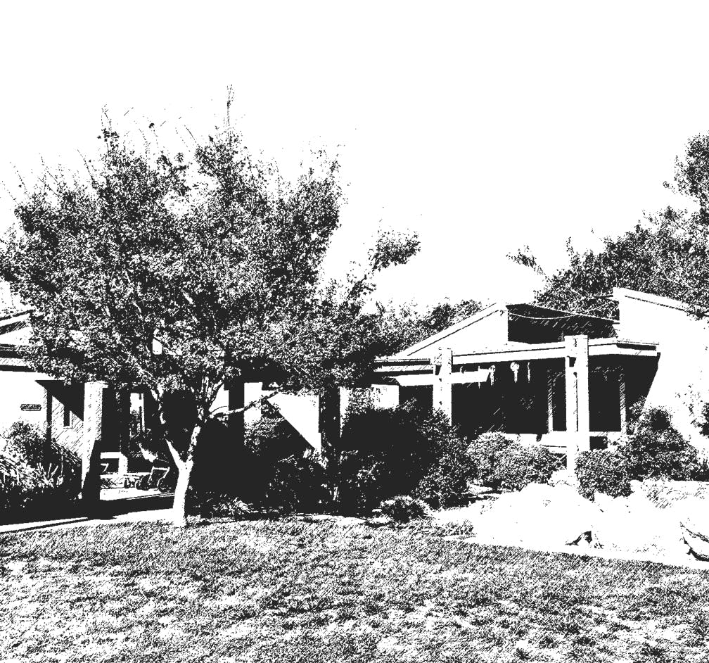 Building with a covered patio and surrounding trees