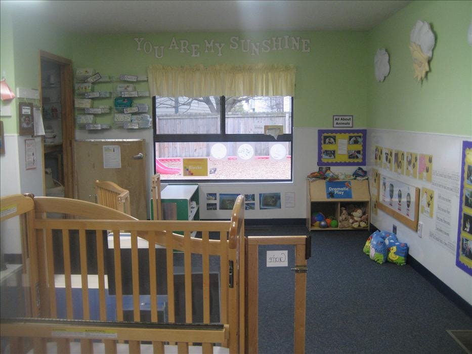 Childcare room with a crib, window looking outdoors, and a play area