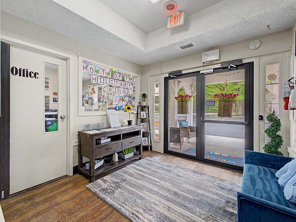 Lobby area with a wooden console table, a blue couch, and glass doors leading outside