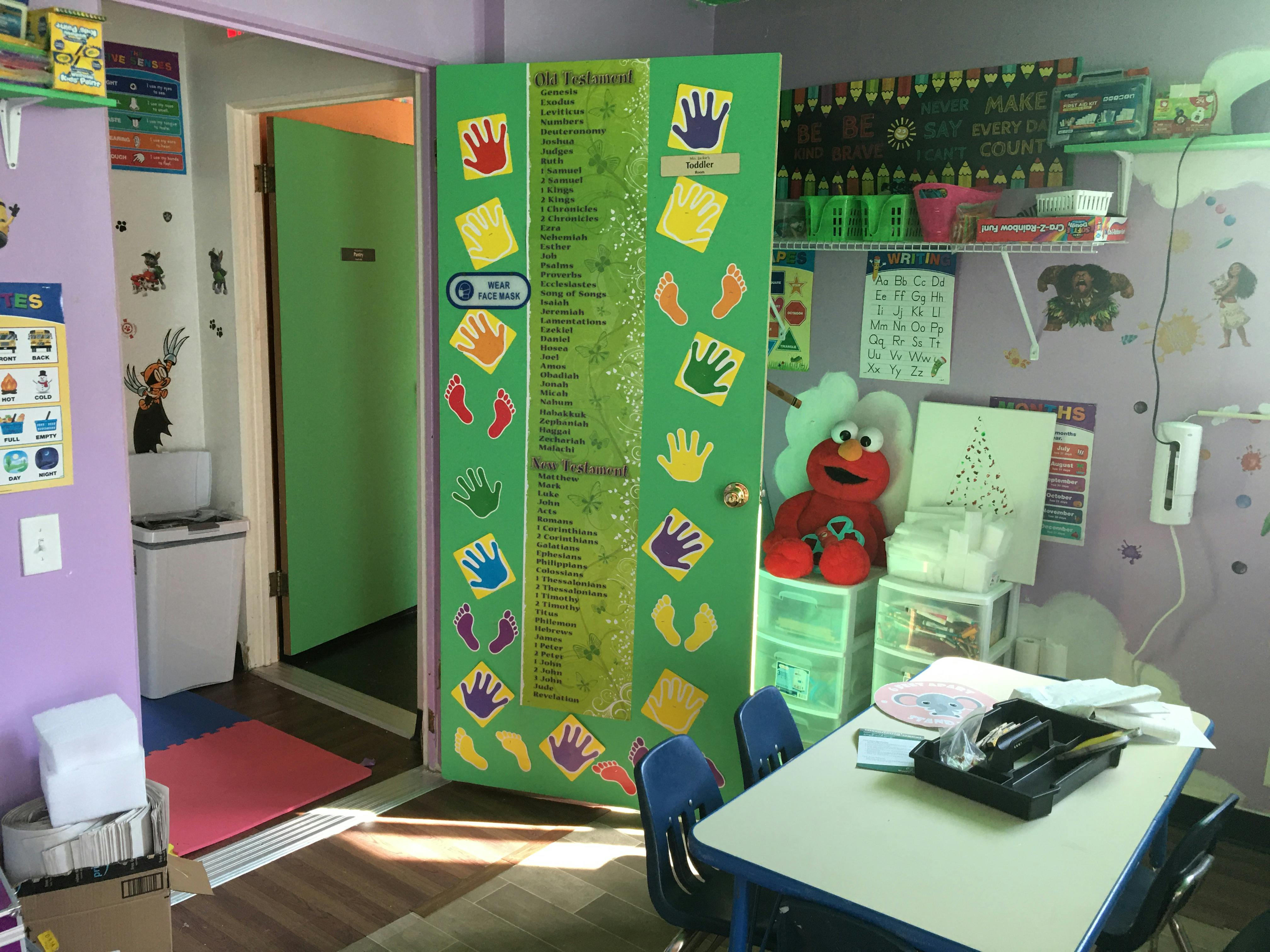 Classroom with a green door decorated with handprints and footprints