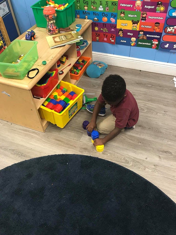 Child playing with colorful toy on the floor