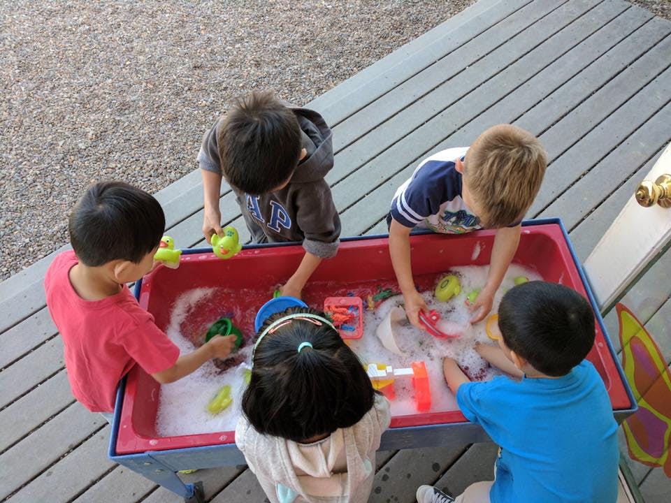 Children playing with toys in a water table