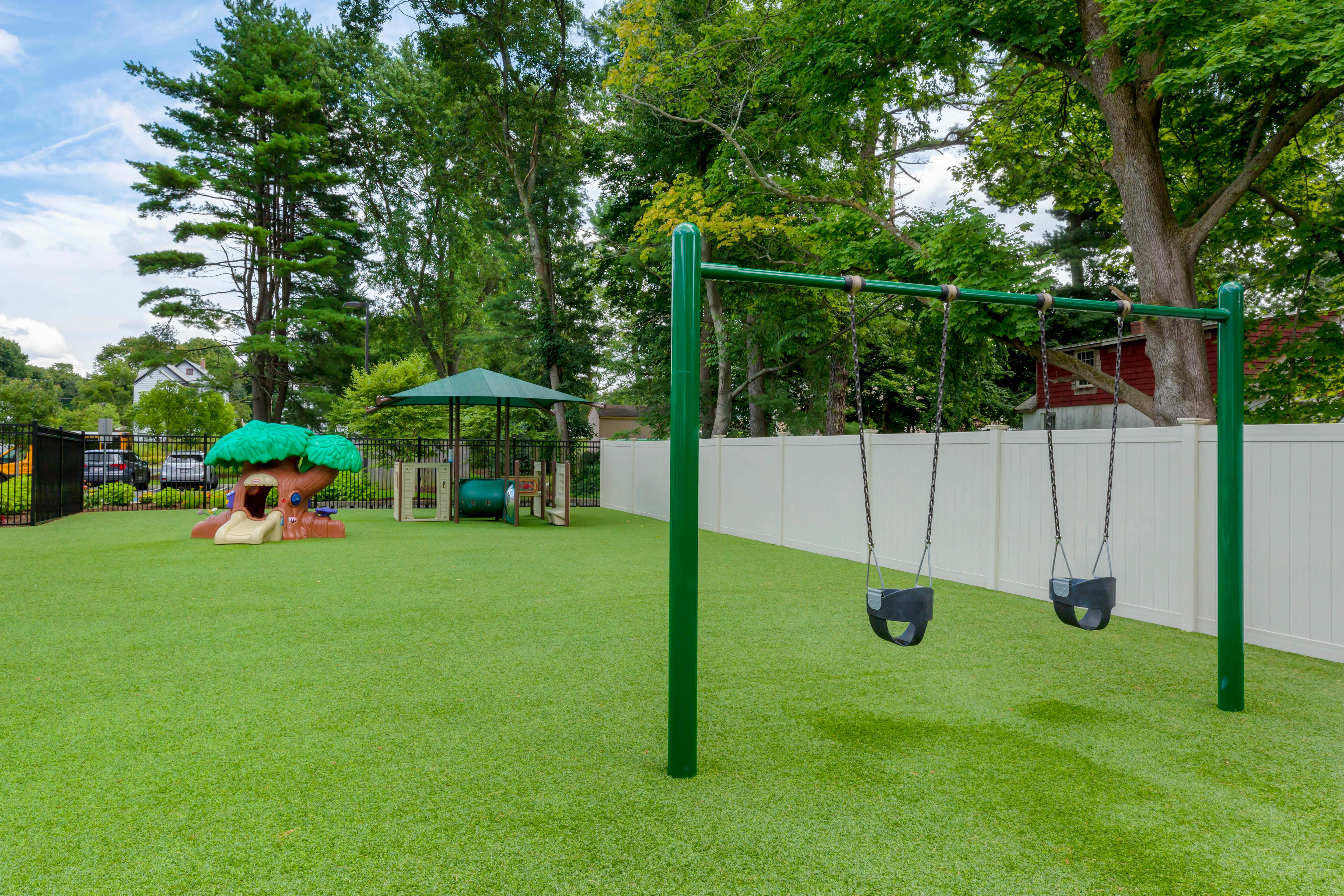 Playground with swings, a tree-shaped slide, and other play structures
