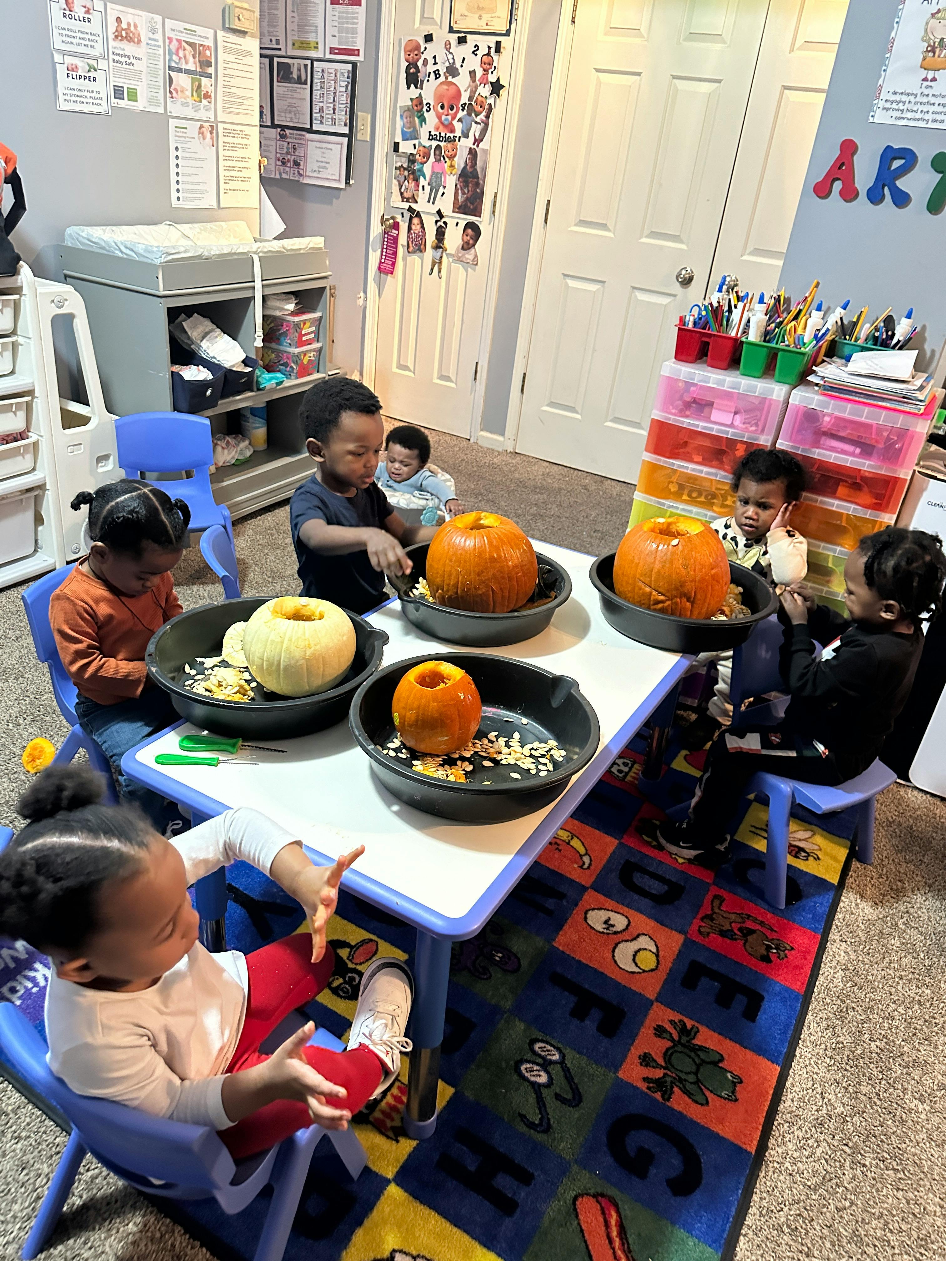 Children carving pumpkins at a table