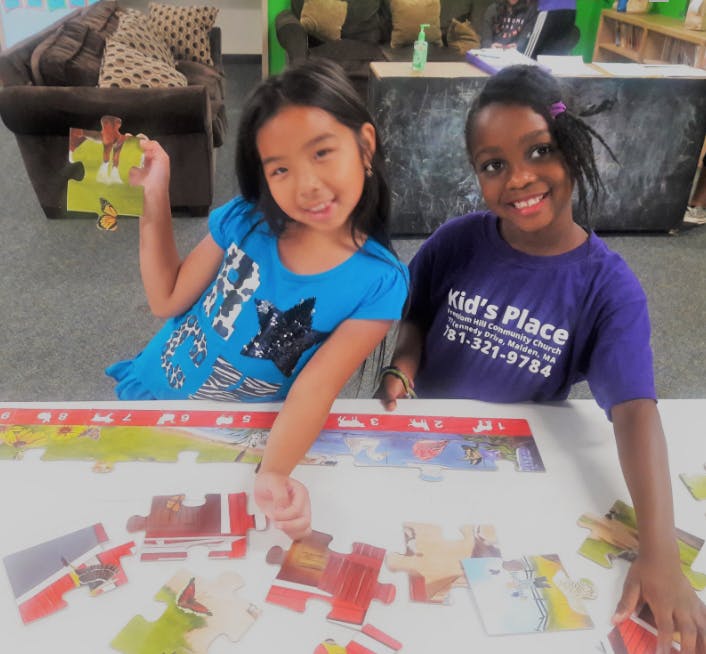 Two children assembling a puzzle