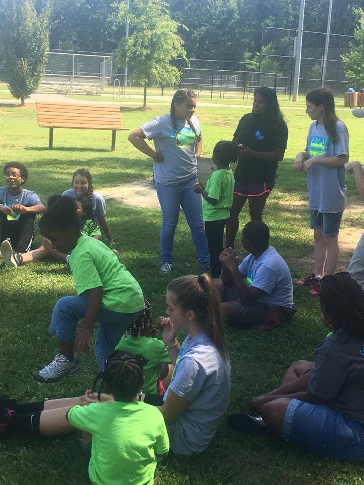 Group of people and children gathered on grass outdoors