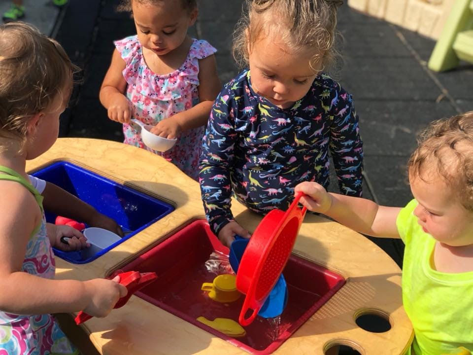 Children playing with water table and toys at a sensory table