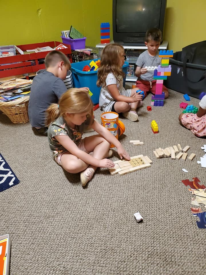 Children playing with building blocks and wooden tiles on the floor